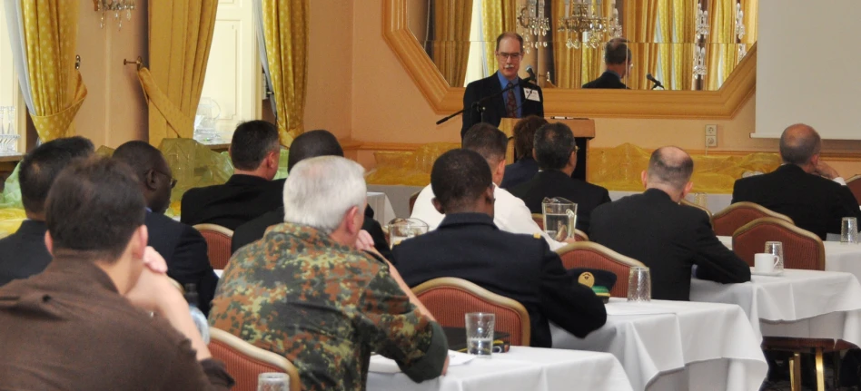 a person stands behind a podium speaking into a crowd