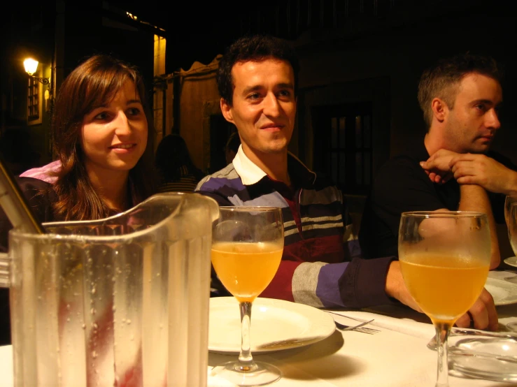 a man and two women sitting at a dinner table