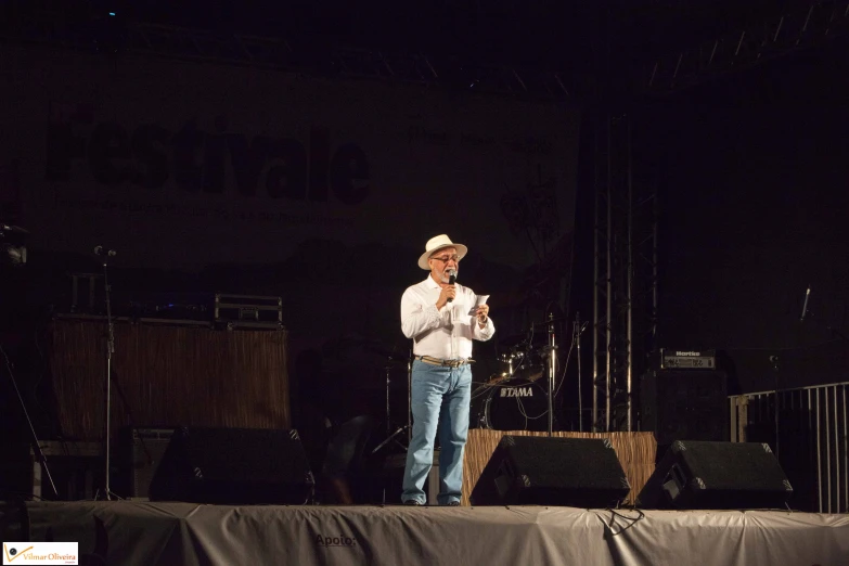 a man stands on a stage with his arms folded