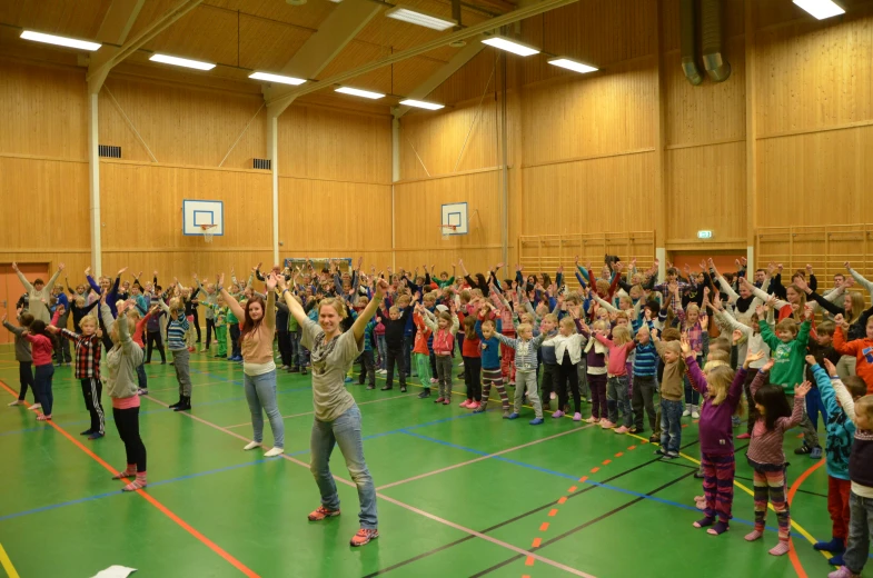 many children doing exercises inside an indoor gym