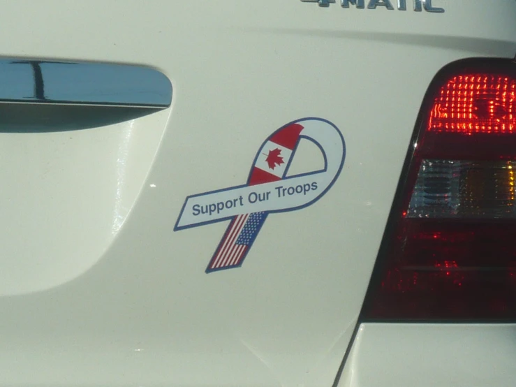 a canadian support our troops sticker is placed on a car