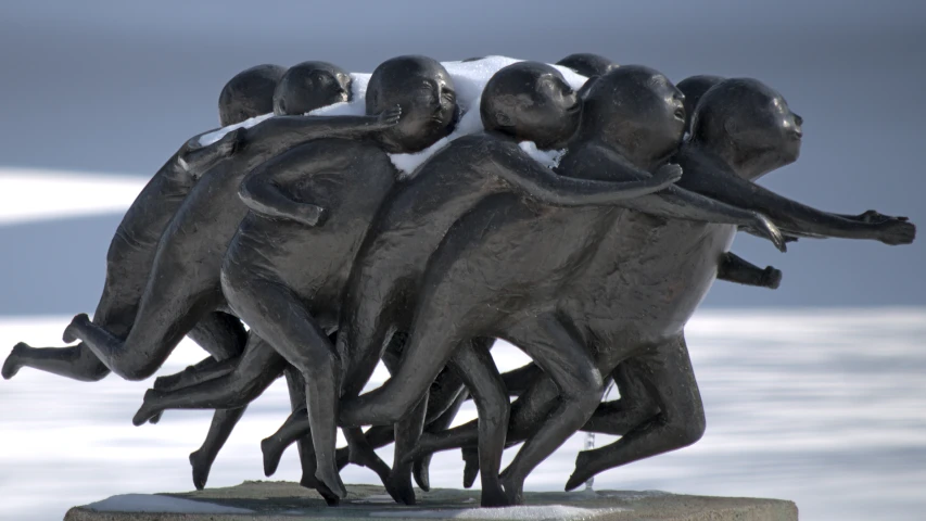 the bronze statue is of four people pulling each other