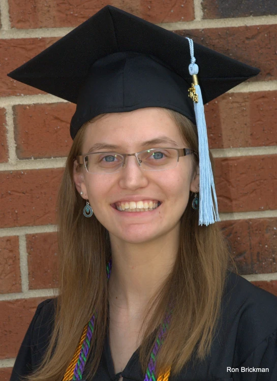 a graduate in a graduation gown with a hat and tassel