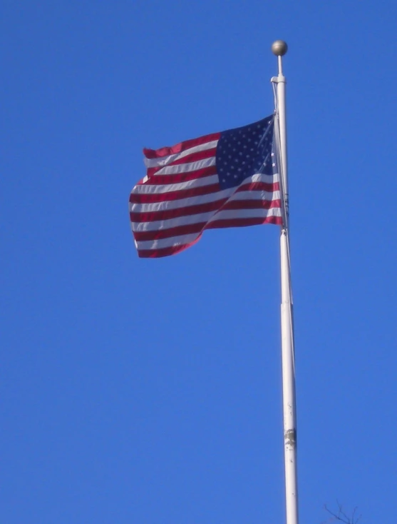 an american flag is flying on a tall pole