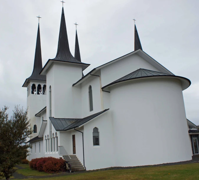 an unusual church on the corner of a hill