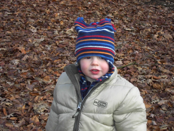a child wearing a striped beanie and coat