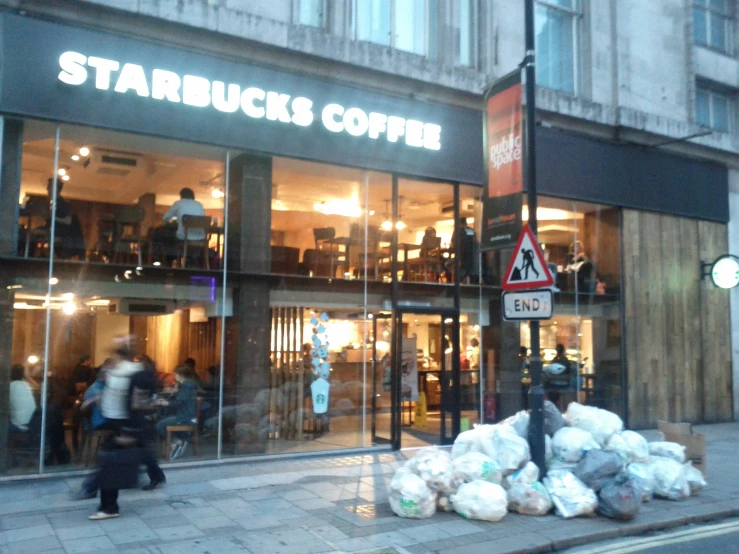 several bags of sand and trash are outside the starbucks