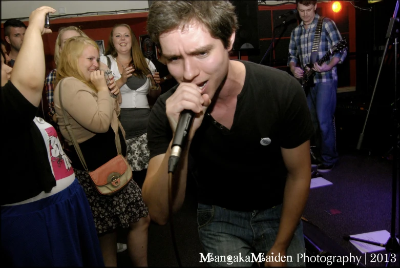 a group of people standing around a man holding a microphone