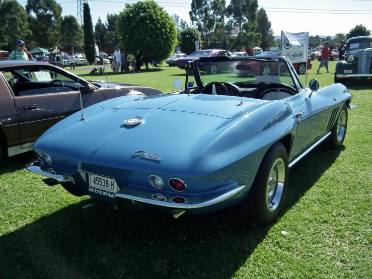 some classic cars parked in a field with other antique cars