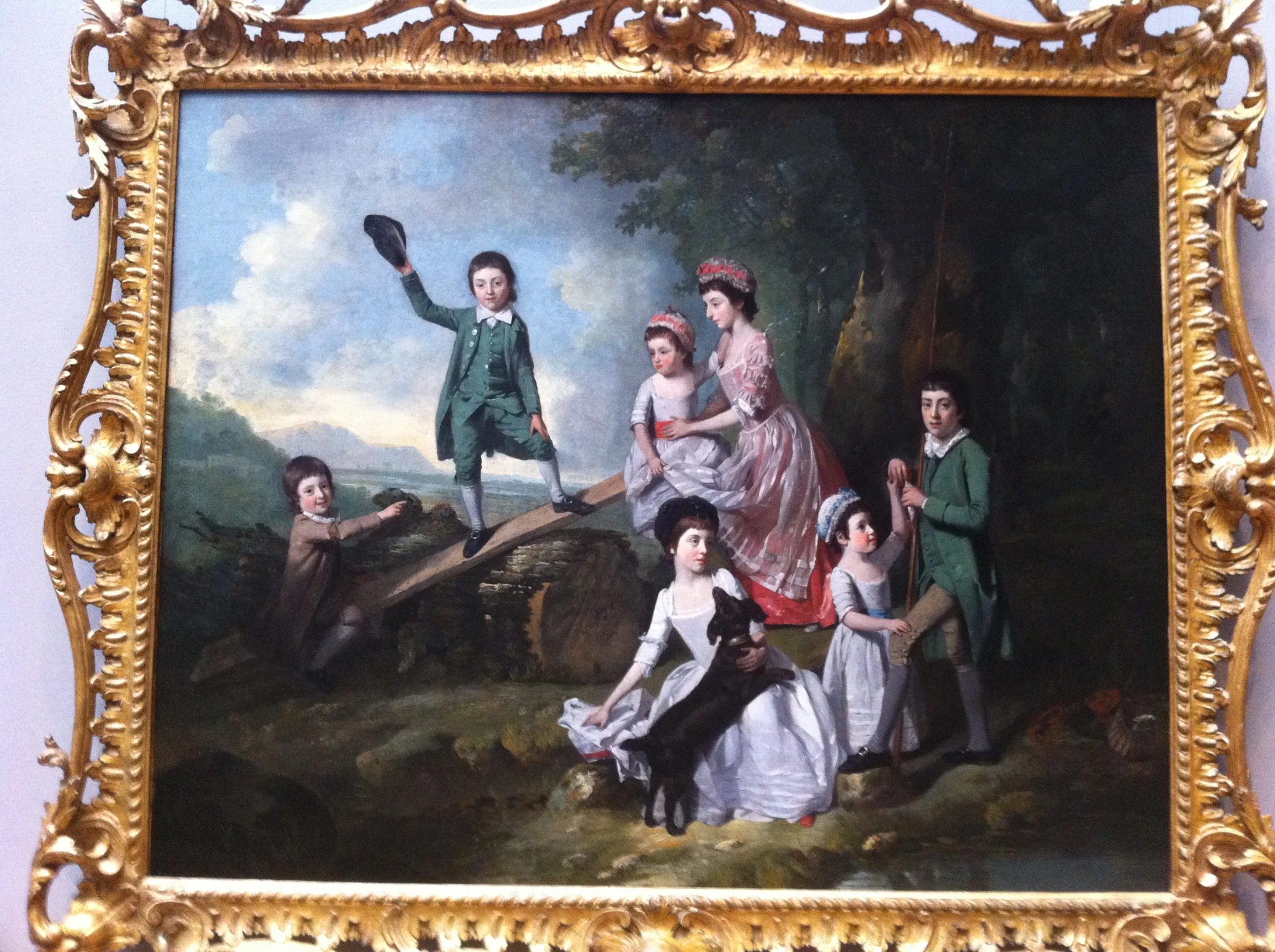 a painting in a gold frame depicting a young family