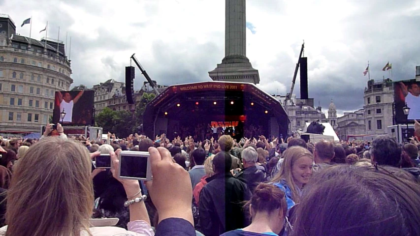 a bunch of people taking pictures while one person holds a phone