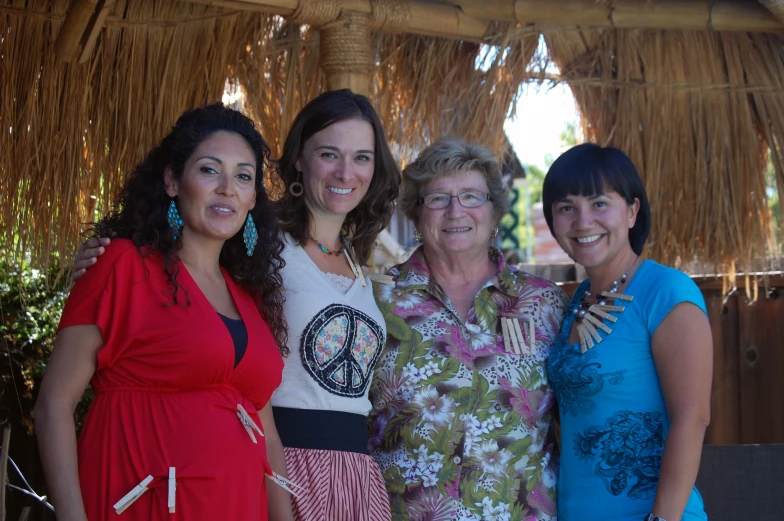 a group of ladies standing next to each other on a wooden deck