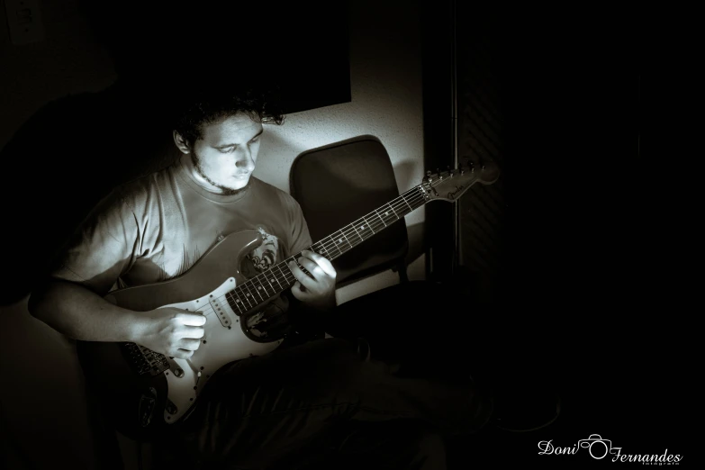 a man plays an electric guitar in the dark