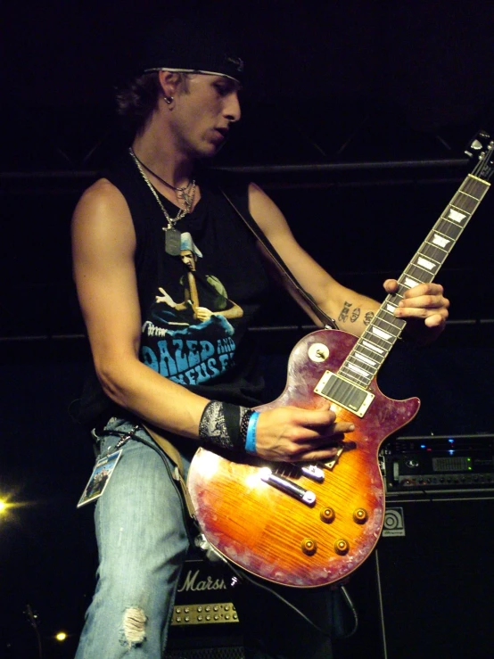 a person holding onto an electric guitar at night