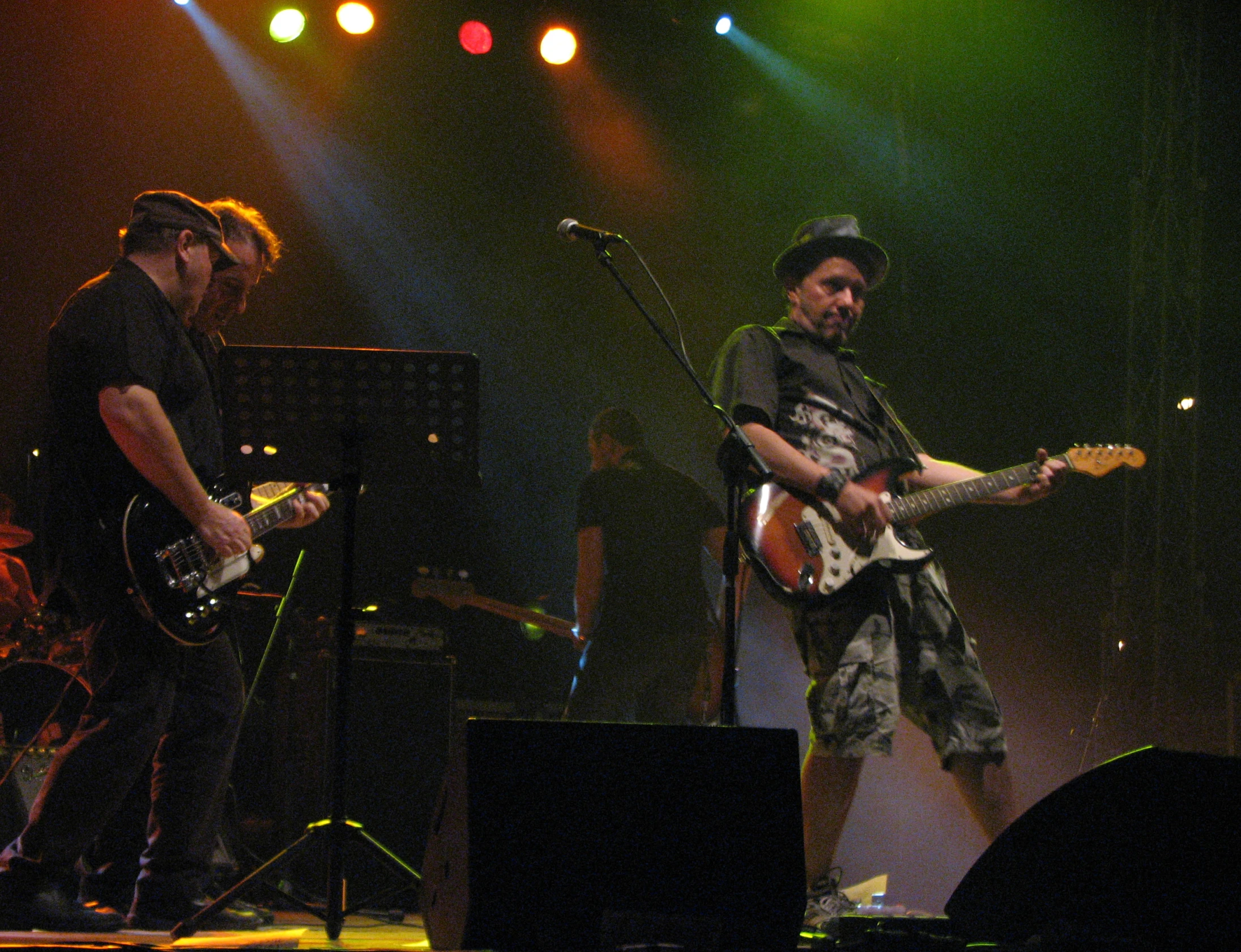 a trio of musicians with guitars on stage