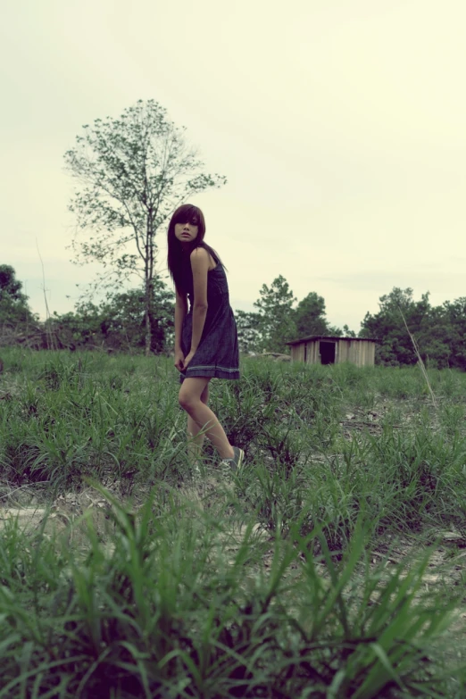 a woman is walking alone outside in a field