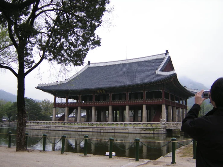 a person taking a pograph in front of an asian building