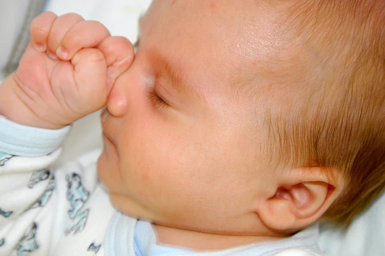 a close up of a baby holding its hands