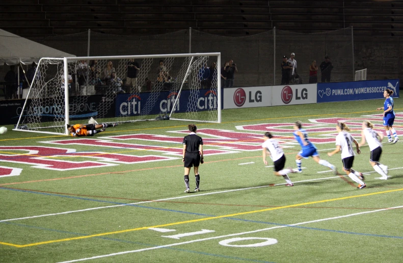 a soccer game in progress with the ball approaching