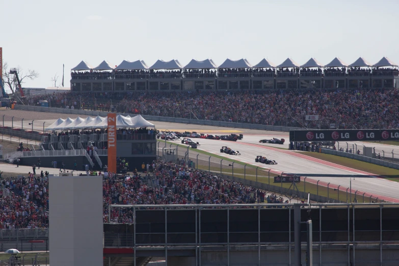 a race track with cars on it and lots of people