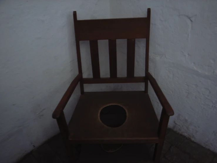 a wooden chair that has an oval hole in it