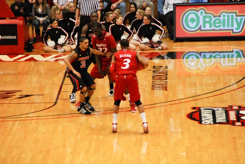 two men playing a game of basketball while people watch