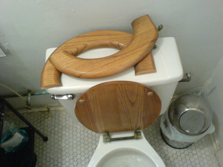 two wood toilet seats with the lid up