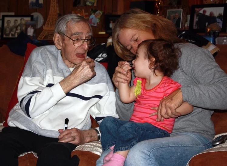 two adults and one child sitting on a couch