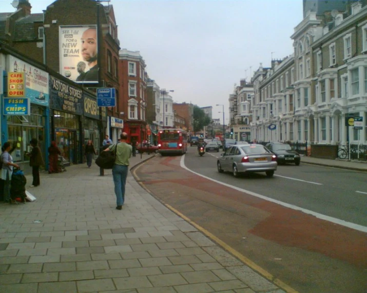 a busy sidewalk near a row of older brick buildings