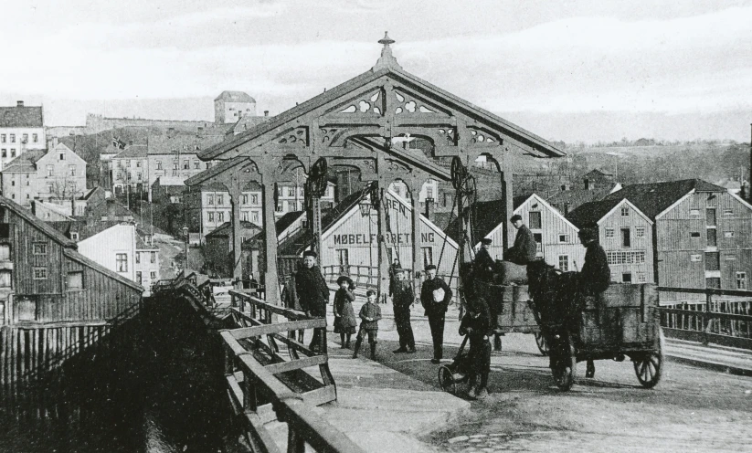 people are on a bike and carriages over a bridge