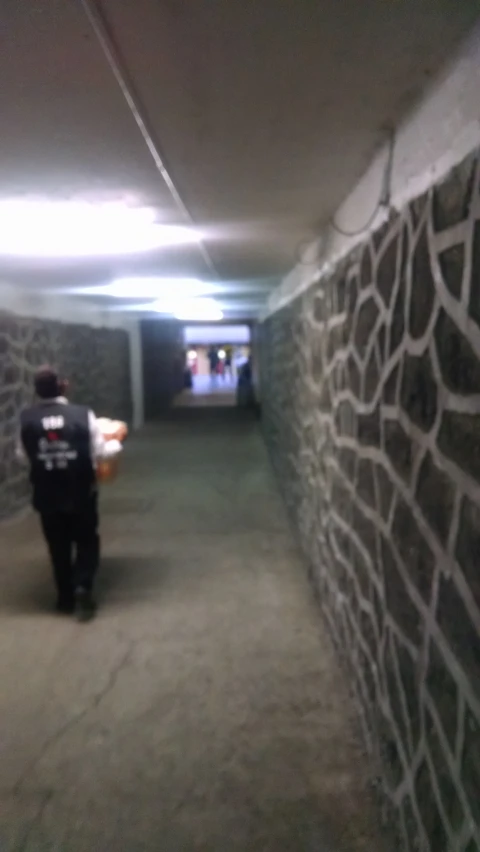 the man is standing in an empty concrete tunnel