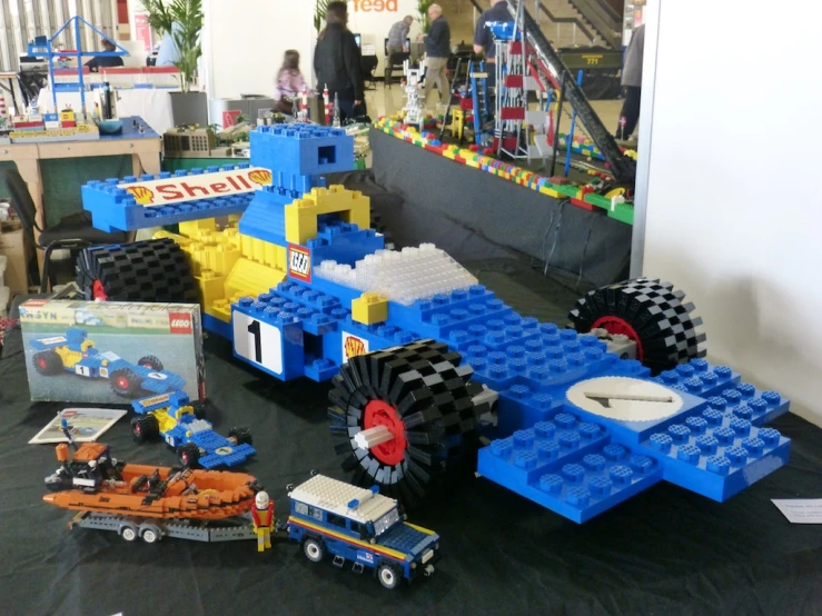 a large lego race car next to some toys