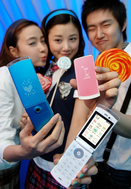 four young people hold various colored electronic devices