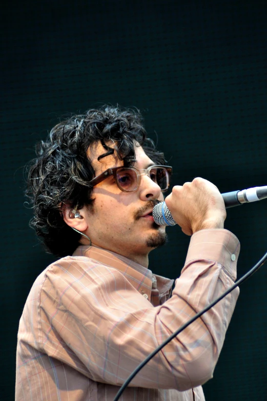 a man with sunglasses holding a microphone in front of his face