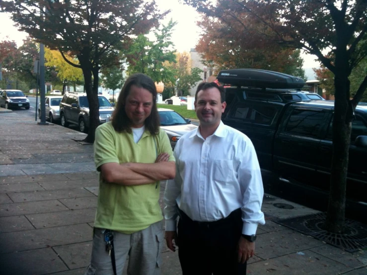 a couple of men are standing in front of some cars