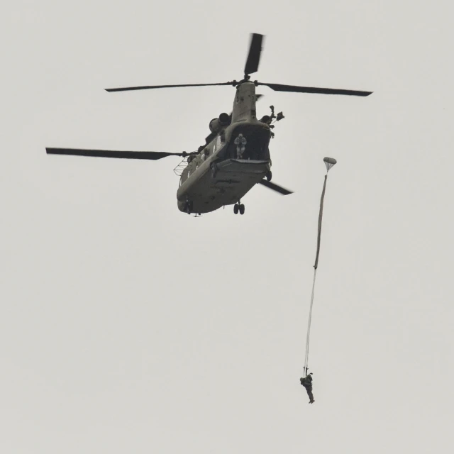 a helicopter and a person hanging from a rope