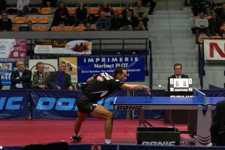 man playing table tennis on an indoor court