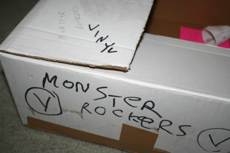 a box with paper and graffiti sitting on the ground