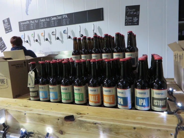 a number of brown beer bottles sitting on top of a wooden table