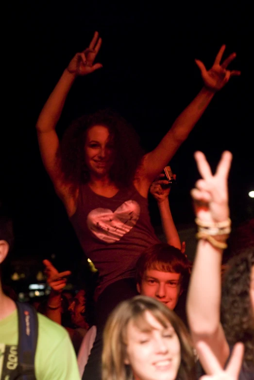 two women making the vulcan sign at an outdoor concert