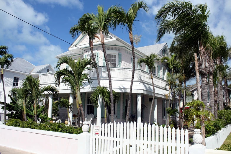 a white fence sits between two very tall houses