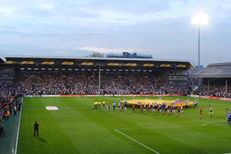 a football field with players and officials preparing for the game