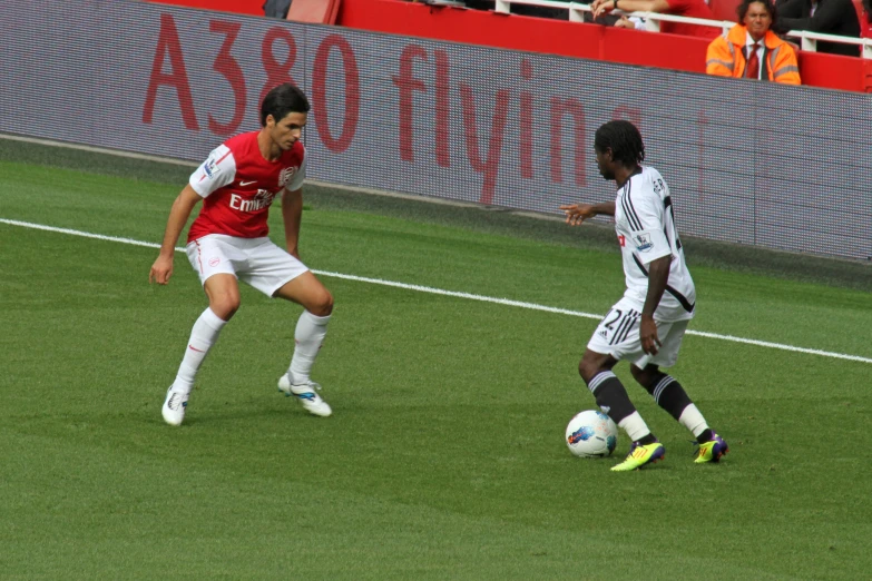 two men playing soccer against each other on a field