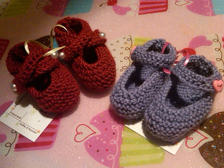 three little knitted shoes are lined up on the table