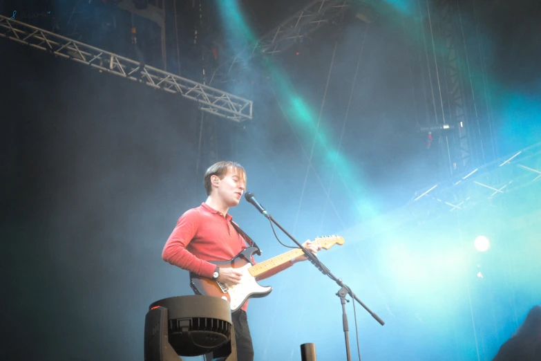 a man on stage with a guitar singing