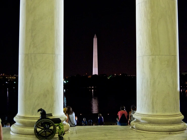 several people gathered under the washington monument at night