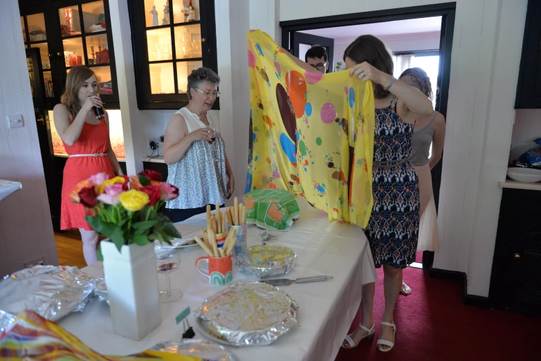 a group of girls stand around a table with decorations on it