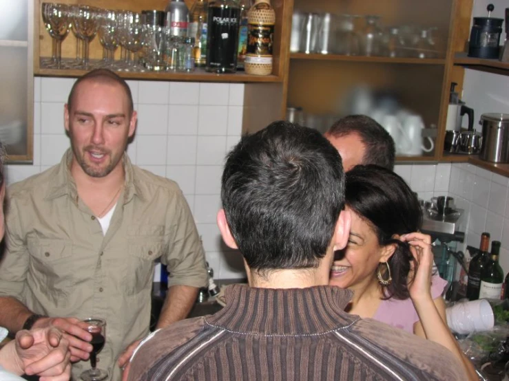 a group of people are standing near a bar