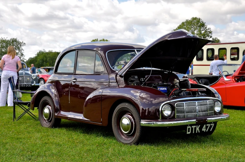 people looking at vintage cars on display at an auto show