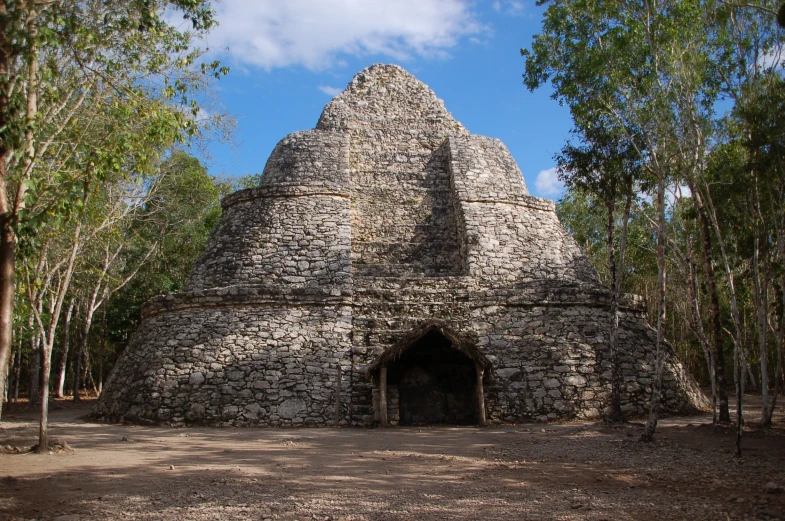 a stone building in the middle of a forest